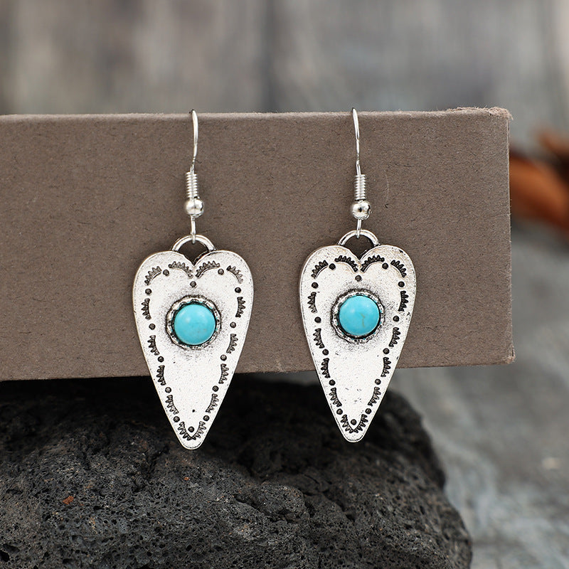 Alloy turquoise heart dangle earrings with silver plating and turquoise accents.