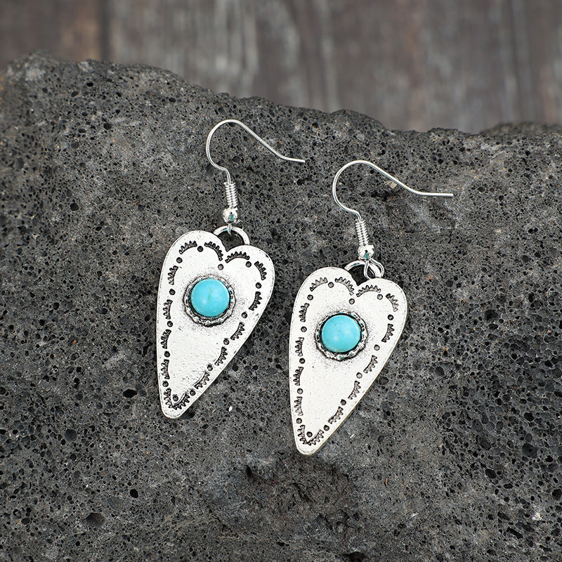 Alloy Turquoise Heart Dangle Earrings with silver-plated design on stone background.