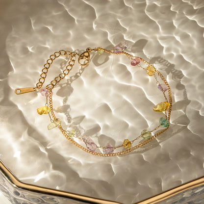 Stainless steel natural stone double layered bracelet with 18K gold-plating on a textured surface.