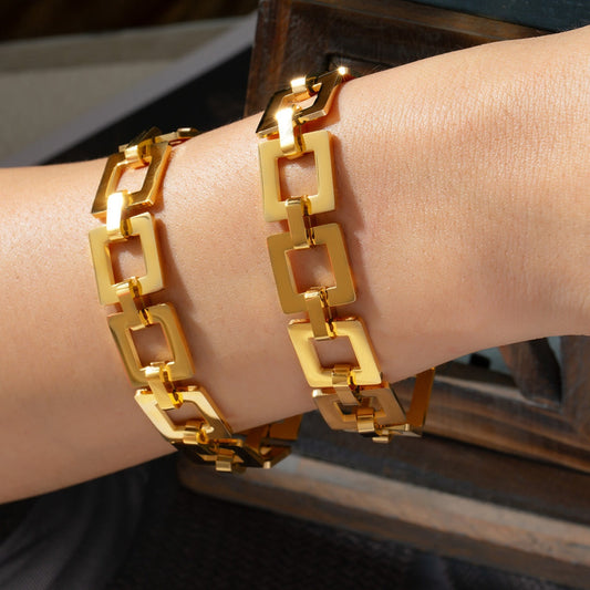 18K gold-plated titanium steel hollow square chain bracelet on wrist.