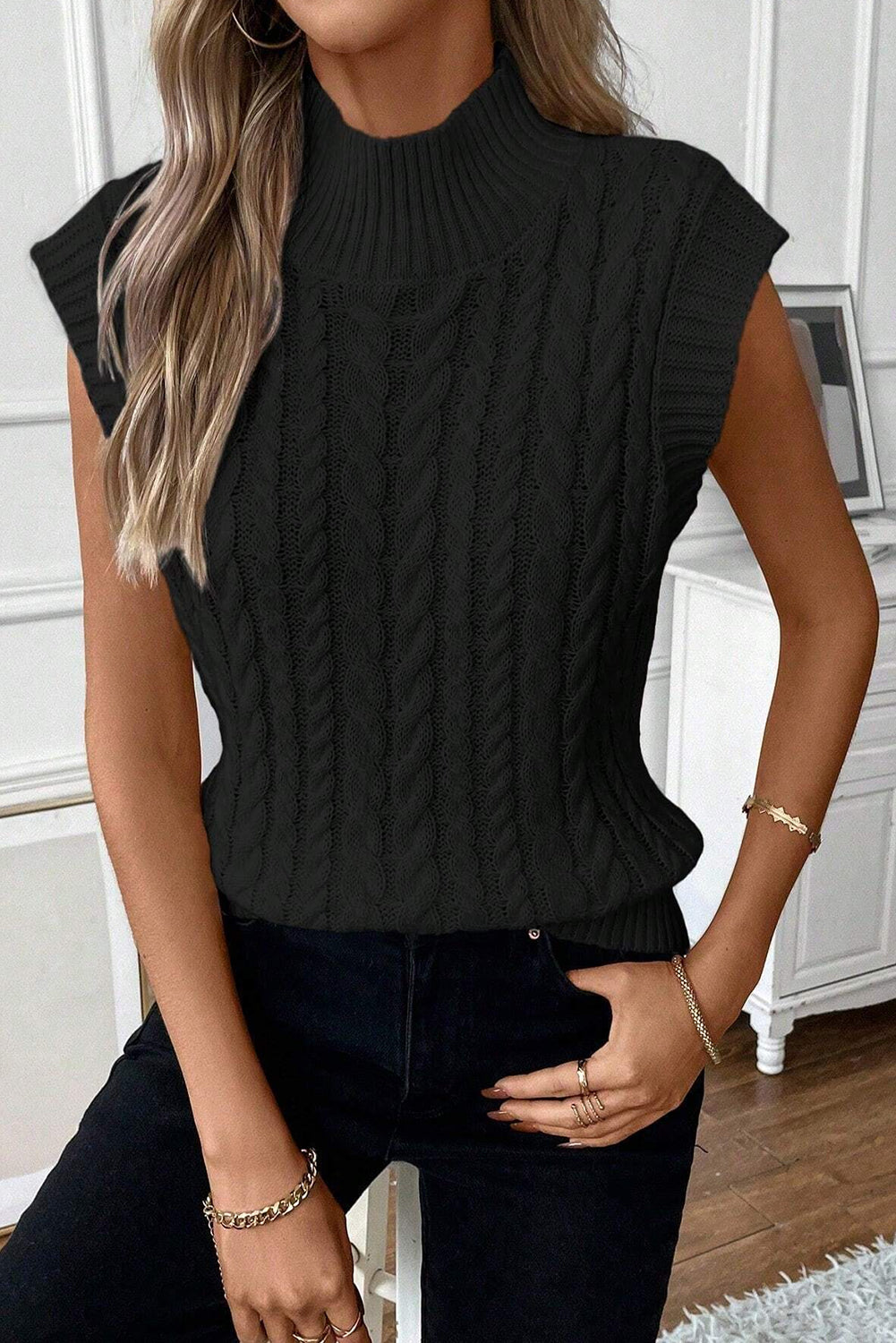 Cable-knit mock neck sweater vest in black, featuring a highly stretchy acrylic material.