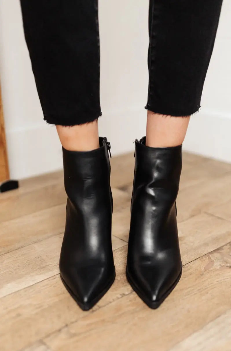 Black faux leather Amari ankle boots with pointed toe and zipper.