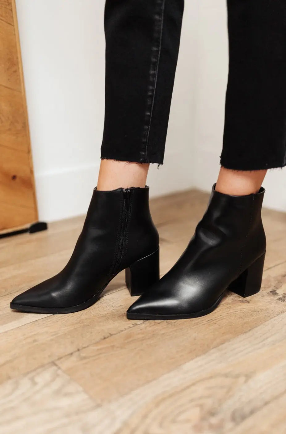 Black Amari ankle boots with pointed toe and faux leather finish.