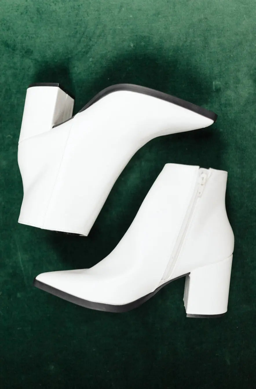 White Amari ankle boots with pointed toe and zipper, faux leather.