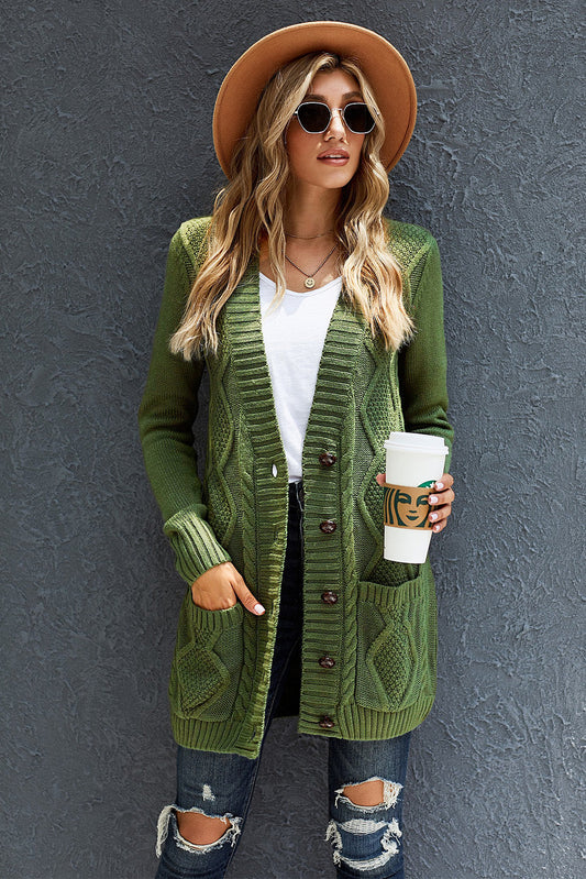 Green cardigan with front pockets and button closure, worn by a woman with sunglasses and a hat, holding a coffee cup.