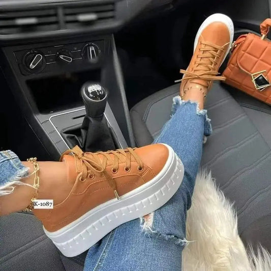 Casual platform women's shoes, flat sneakers, brown color, worn with ripped jeans.