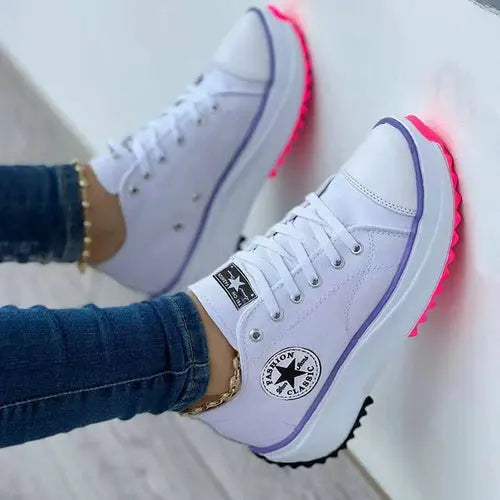 Flat lace-up sneakers with patterned canvas design, perfect for casual and sporty looks.