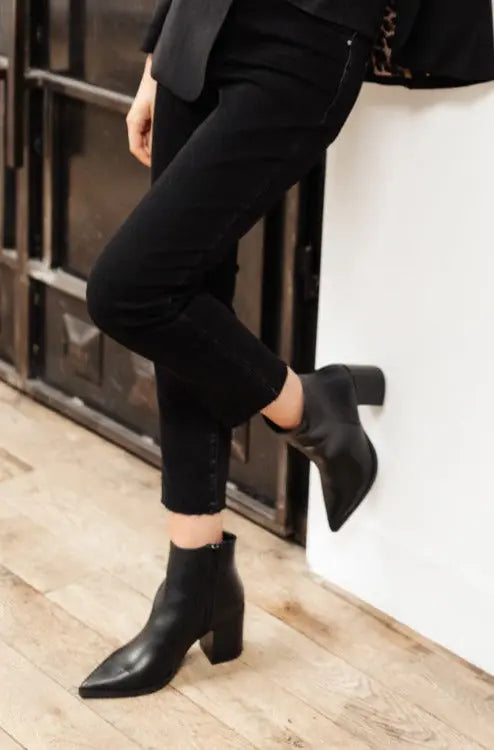 Black Amari ankle boots with pointed toe and faux leather design.