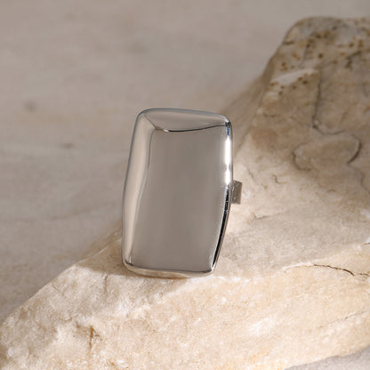 Stainless steel rectangle adjustable open ring on a stone surface.