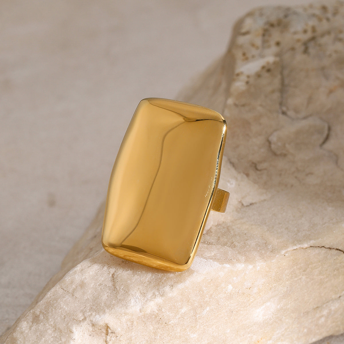 18K gold-plated stainless steel rectangle adjustable open ring on stone background.