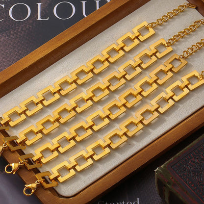 Titanium steel hollow square chain bracelet with 18K gold plating on a wooden tray.