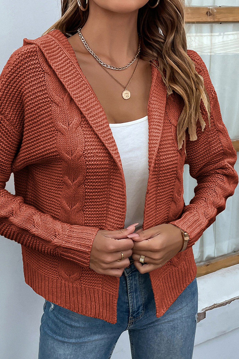 Cable-Knit Dropped Shoulder Hooded Cardigan in rust color, featuring open front design and cable-knit pattern.