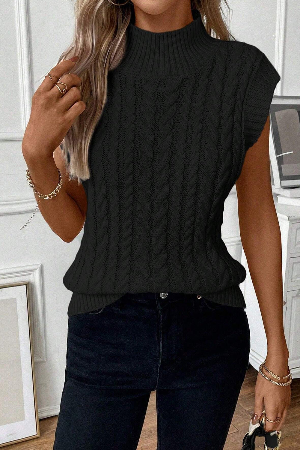 Cable-knit mock neck sweater vest in black, highly stretchy, 100% acrylic.