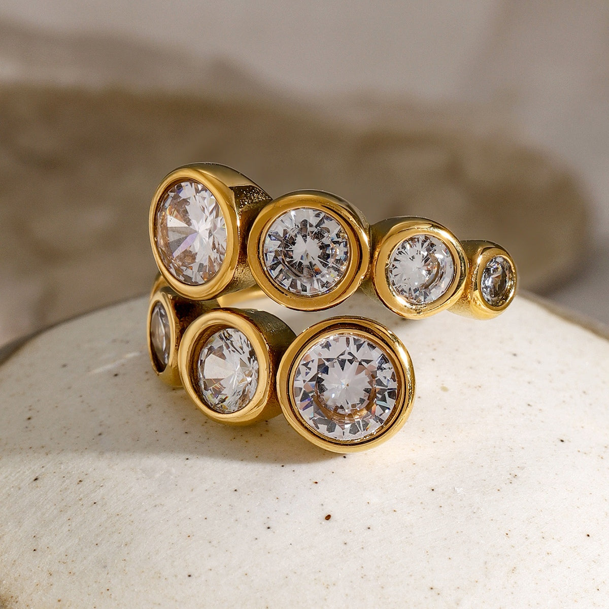 Elegant Stainless Steel Inlaid Zircon Bypass Ring with 18K gold-plated finish and sparkling zircon stones.