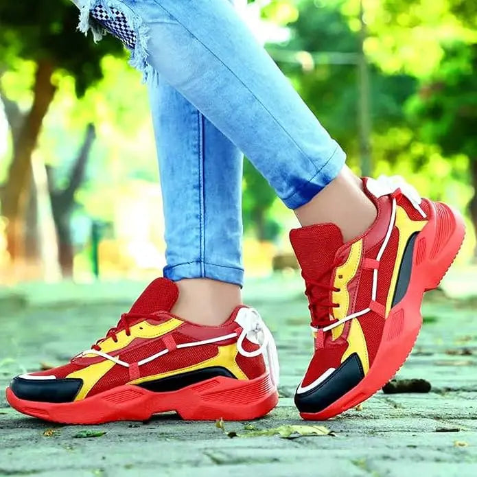 Designer lace-up outdoor gym-wear casual sports shoe in red and yellow, size UK 9, on person standing outdoors.